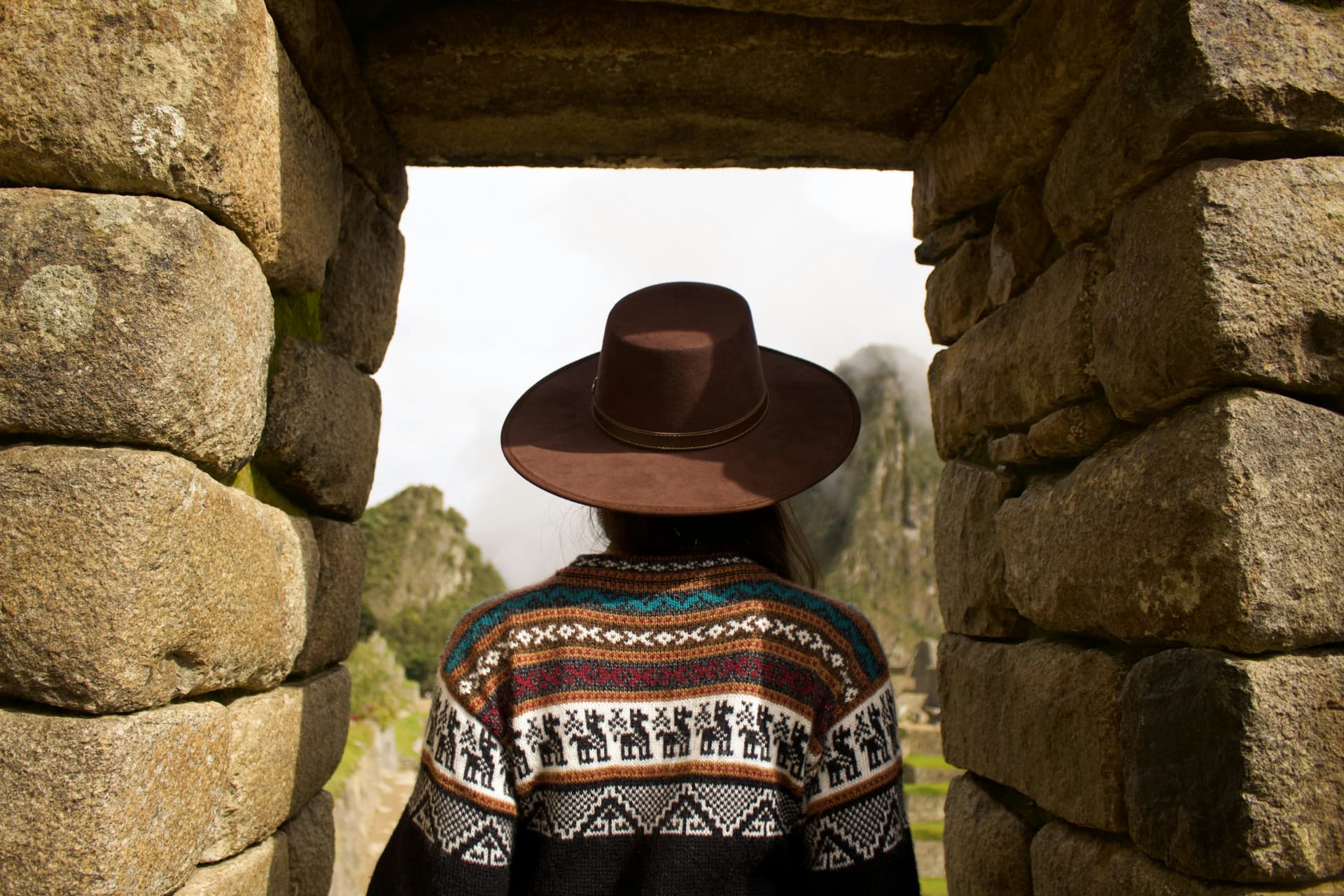 Donna con cappello davanti alle rovine di Machu Picchu, in Perù